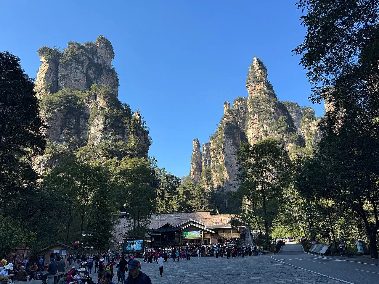 Visitors queuing by the lower Bailong Elevator arrival area beneath sandstone cliffs