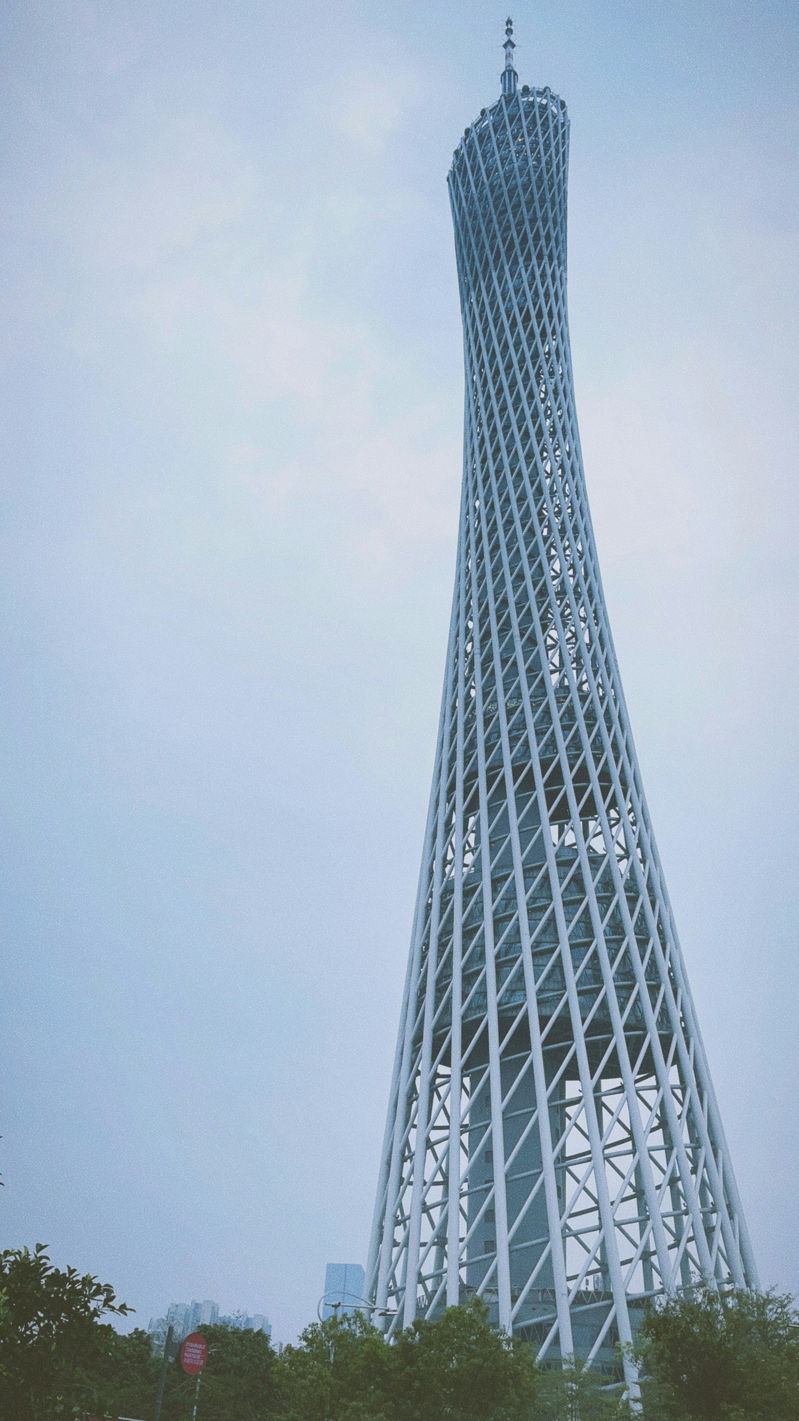 The upper section of Guangzhou’s Canton Tower beneath a cloudy sky