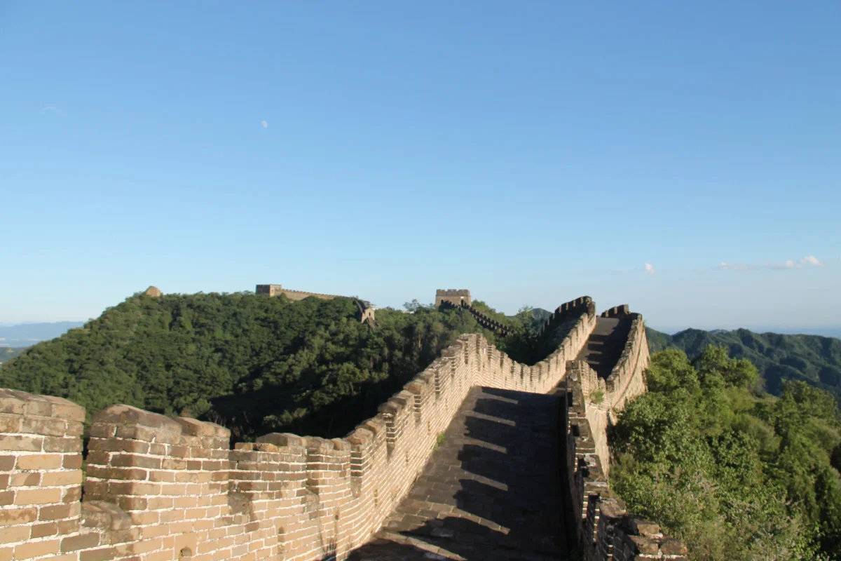 Restored towers and steep stone steps along the Mutianyu Great Wall in green hills