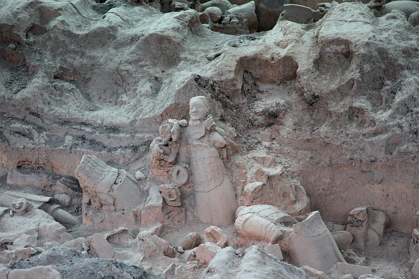 Terracotta figures and broken sculptures among the excavated earth walls of Pit 1