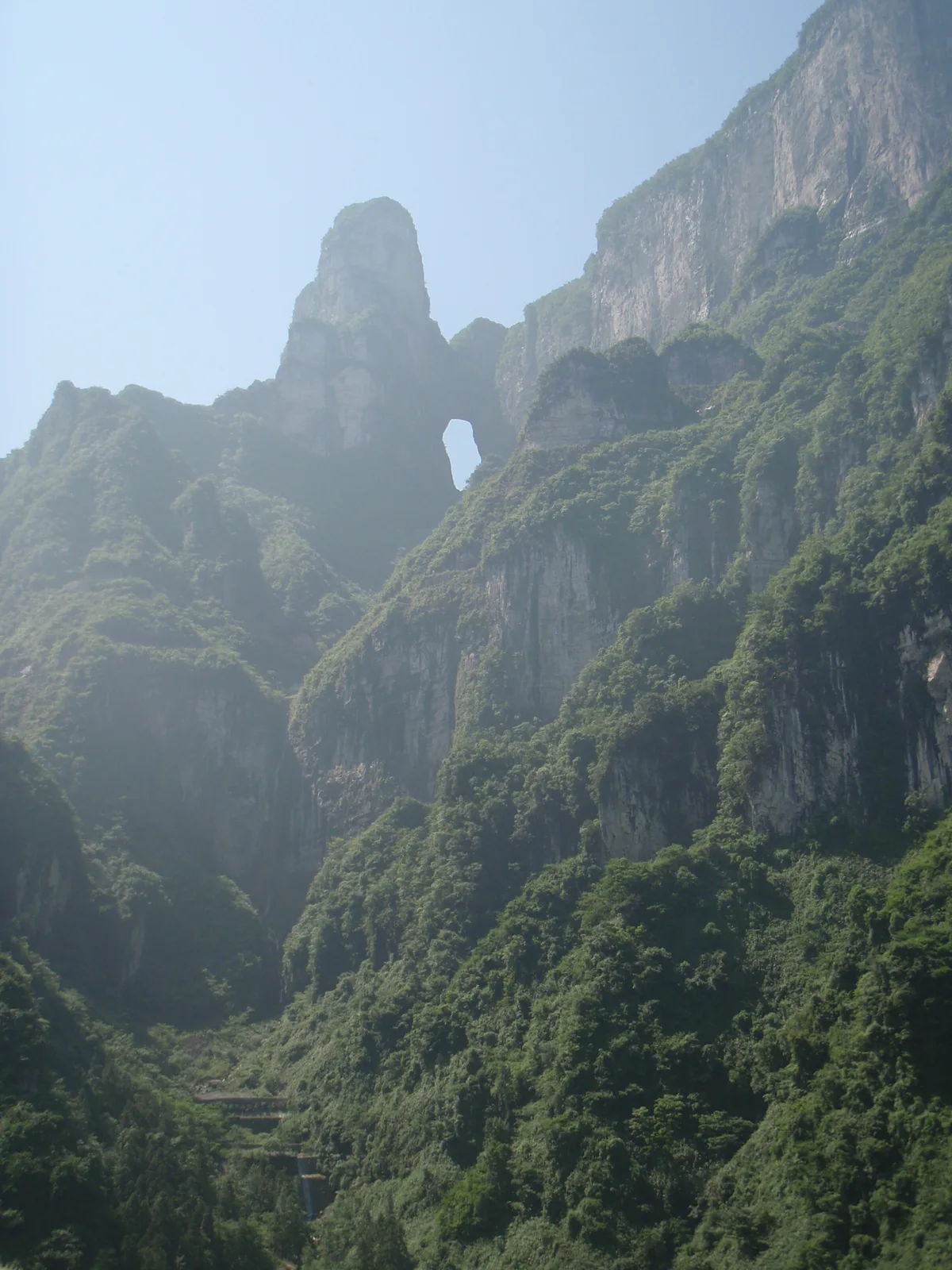 Tianmen Cave’s natural arch high in the green cliff face above the mountain approach