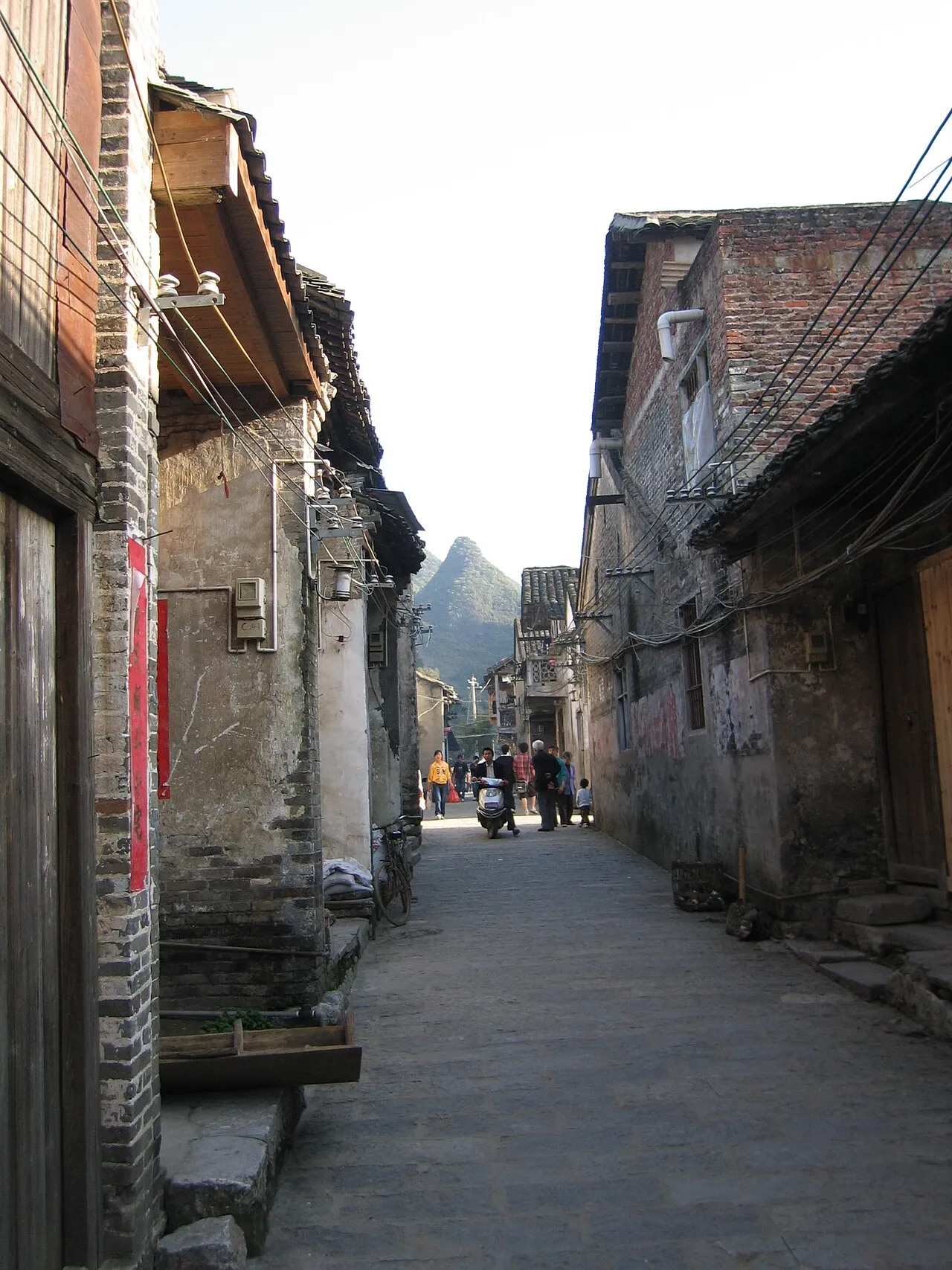 A narrow stone-paved lane between old buildings in Xingping