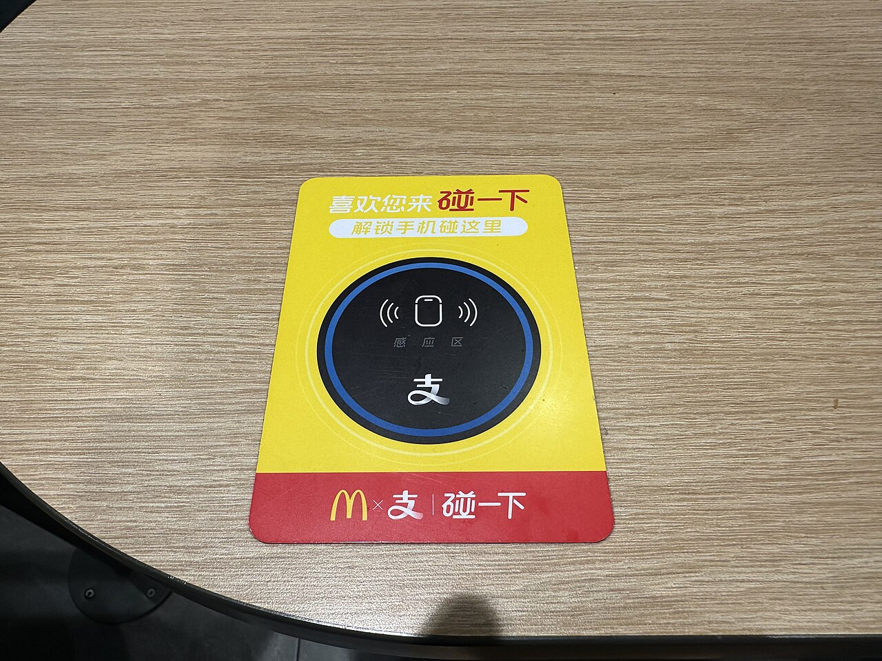 An Alipay tap-to-pay sign on a restaurant table in Dongguan, China