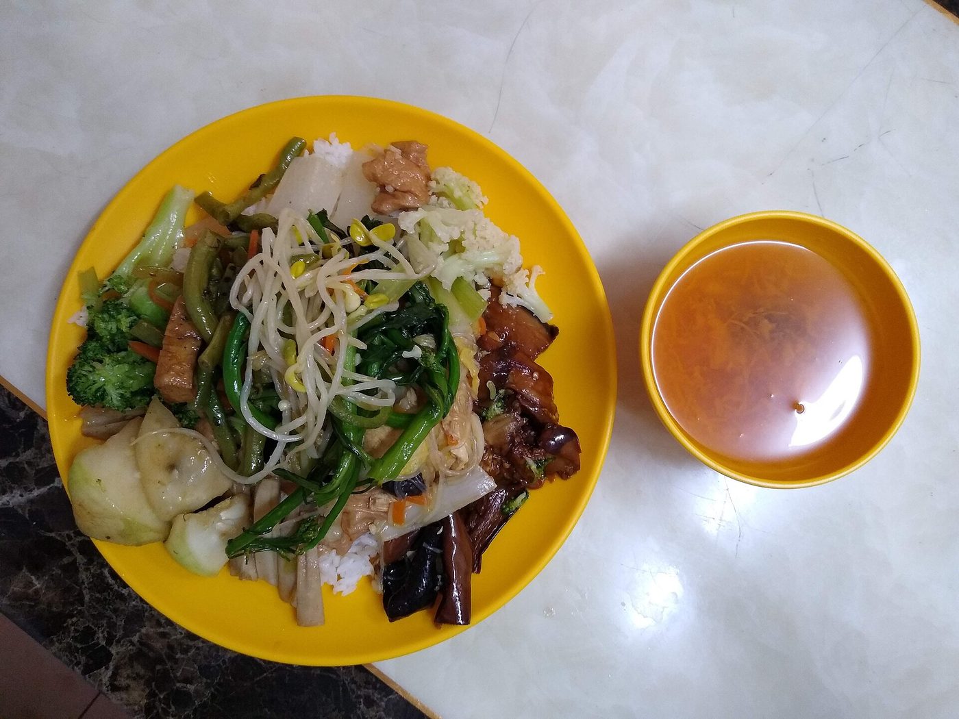A plate of rice, vegetables and bean sprouts with soup at a vegetarian restaurant in Guangzhou